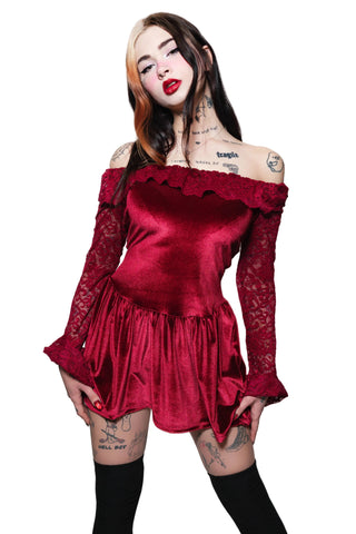 Woman wearing a red satin dress with long sleeves against a white background