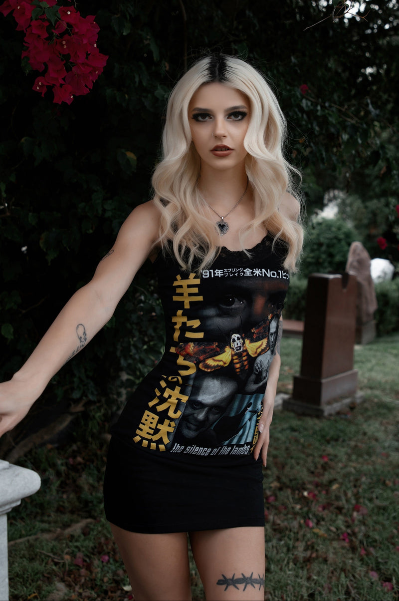 Woman wearing a black tank top with graphic design in an outdoor setting