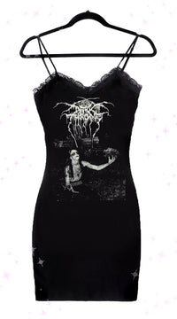 A black lace strap dress with a graphic print on the front, displayed on a hanger.