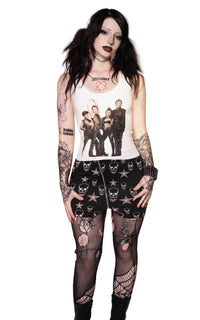 Person wearing a sleeveless top with graphic design and black lace pants on a white background