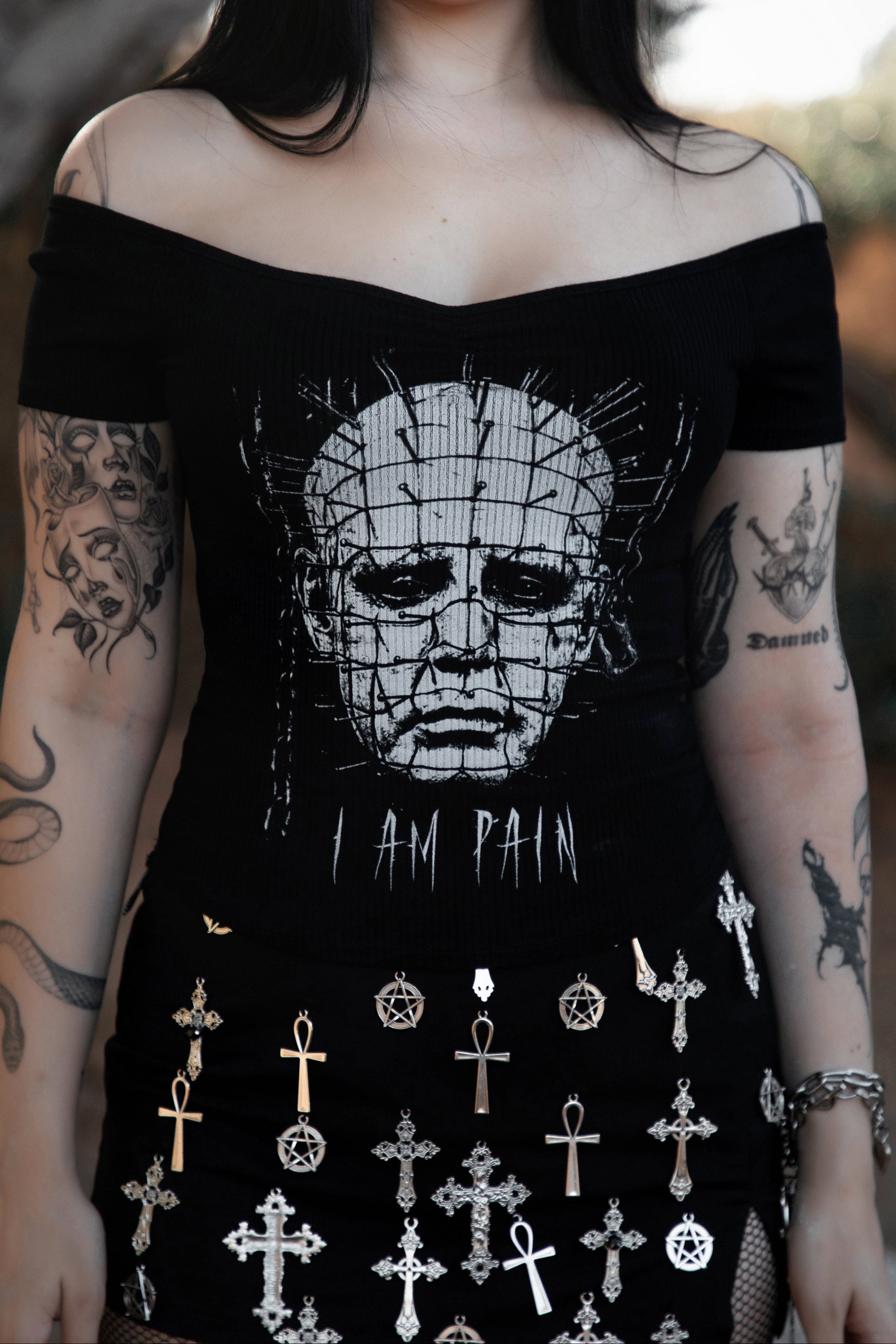 Person wearing a black off-shoulder top with a graphic design and text.