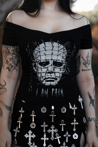 Person wearing a black off-shoulder top with a graphic design and text.