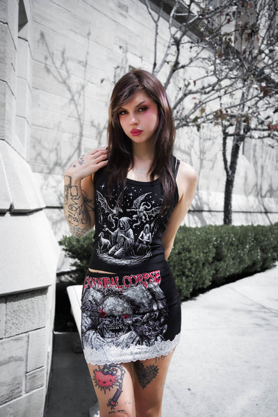 Woman wearing a black tank top with graphic designs outdoors.