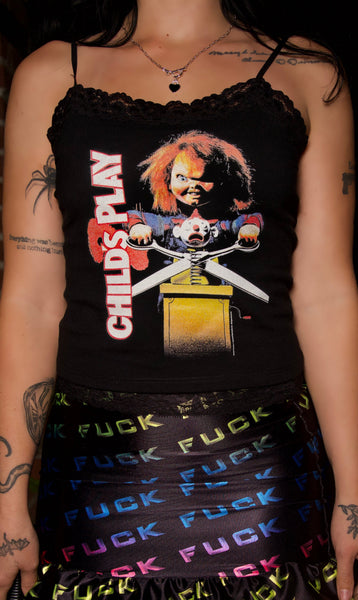 Person wearing a black tank top with a graphic design and a colorful skirt with text.