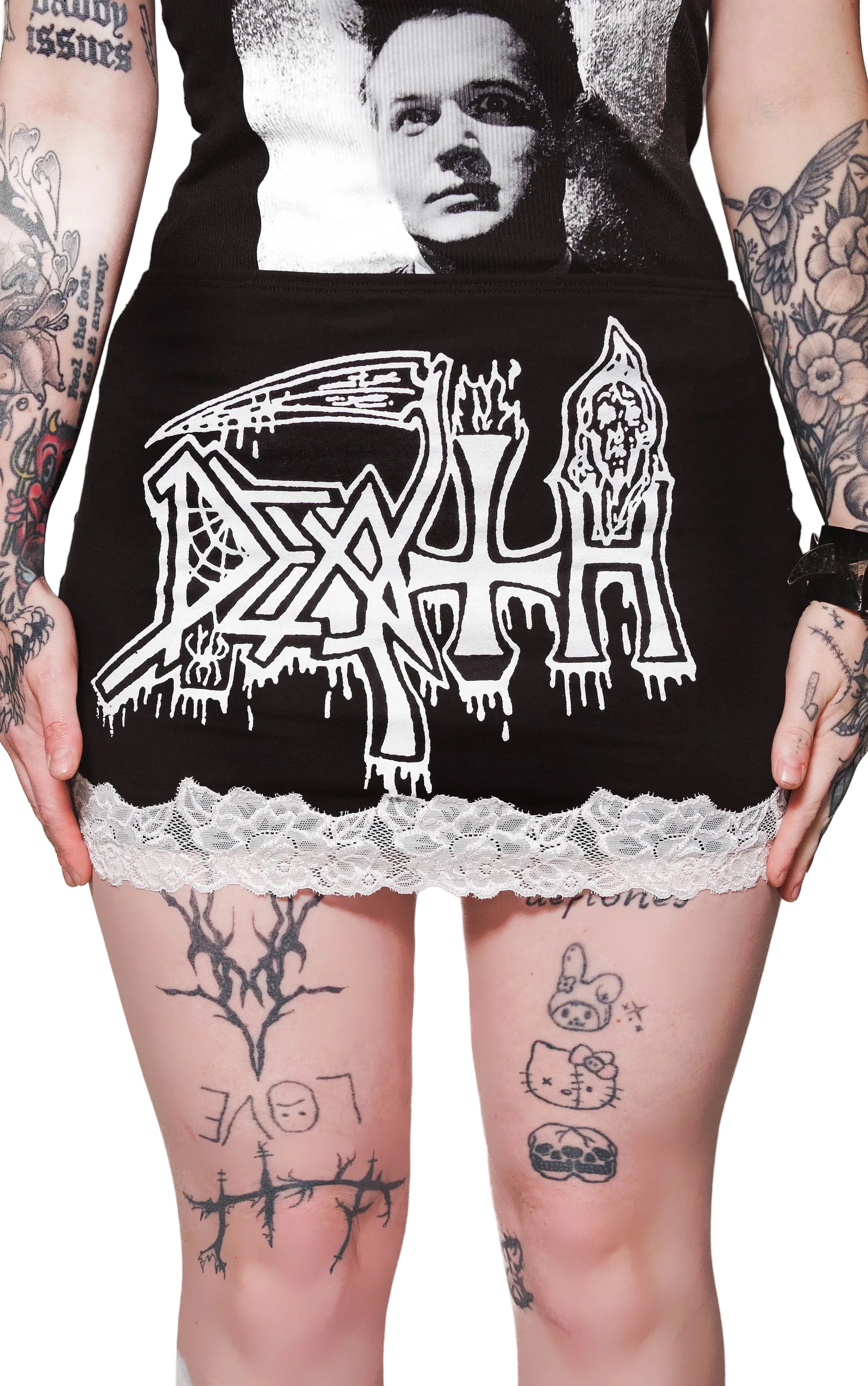 Person wearing a black hoodie with 'Death' logo and lace trim, tattoos visible on arms and legs.