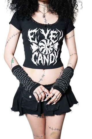 Person wearing a black t-shirt with white graphic design and black skirt on a white background