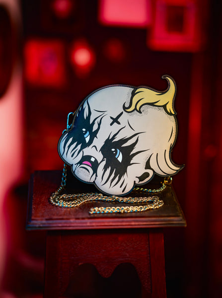 Handbag with a face design on a wooden stand against a red background