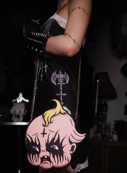 Person holding a bag with a face design in a dark setting