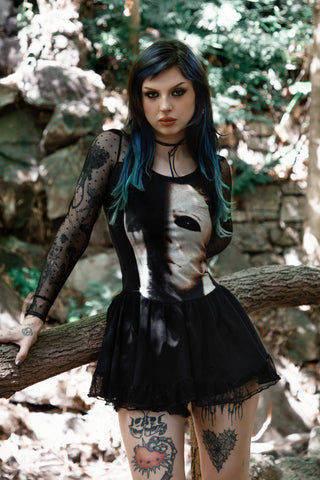 Person with tattoos in a forest setting