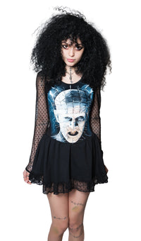 Person wearing a black dress with a graphic design on a white background