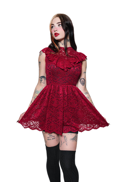 Woman wearing a red lace dress on a white background