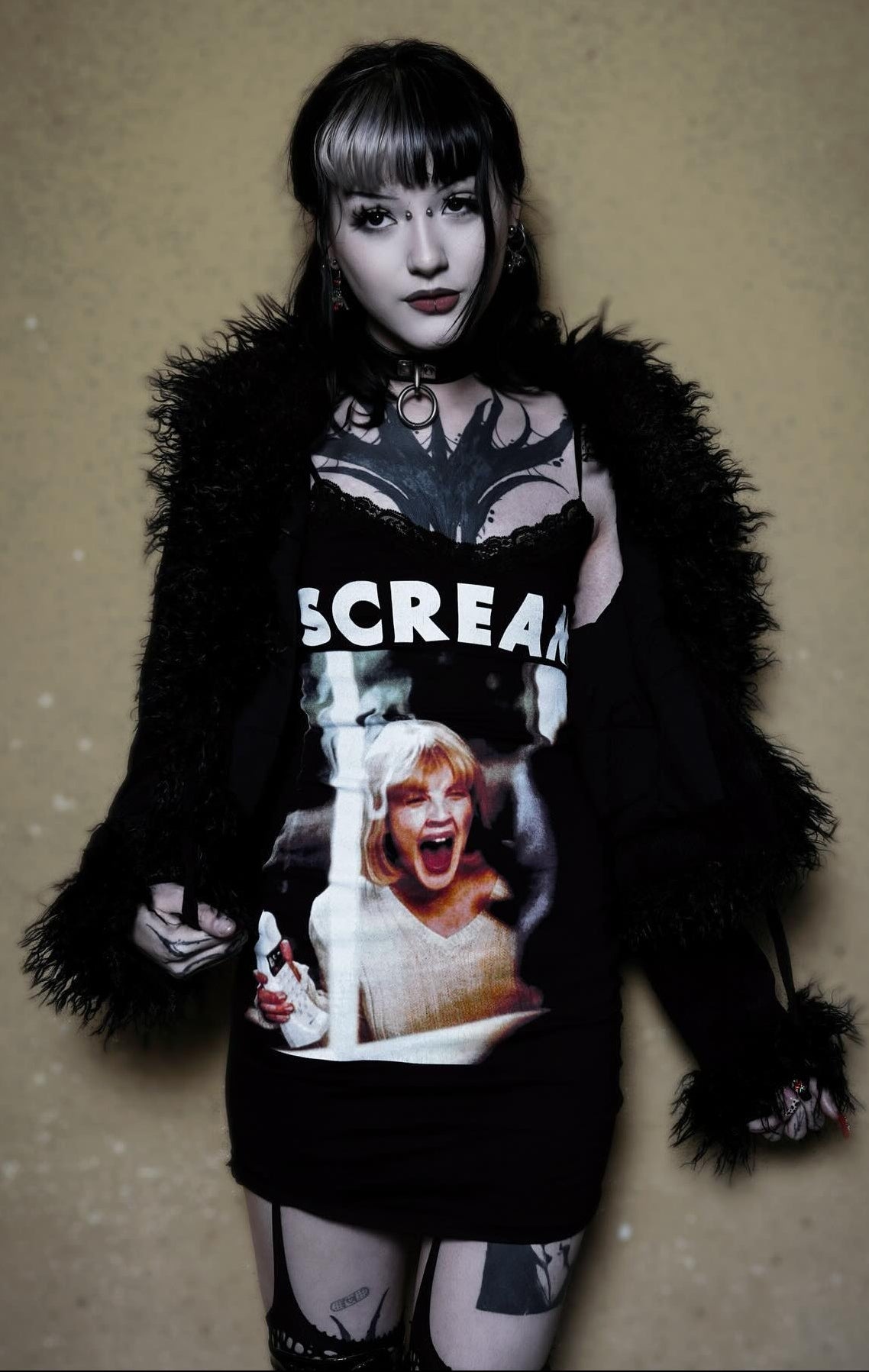 Person wearing a 'Scream' themed outfit with a black fur coat and graphic t-shirt.
