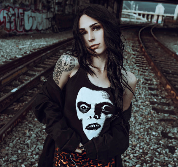 Black tank top. Features white print face of Pazuzu.