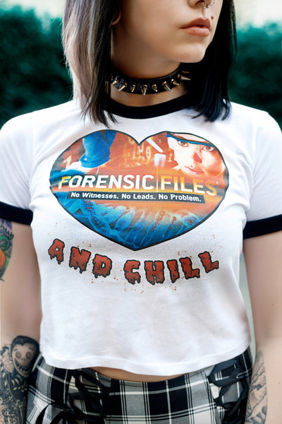 White ringer tee with black trim. Features lab scientist and "Forensic Files and Chill" written. Inscription also reds "No Witnesses, No Leads, No Problem."