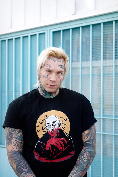 Black short sleeve T-shirt. Features white and orange image of vampire. Yellow full moon and black bats in background of image.