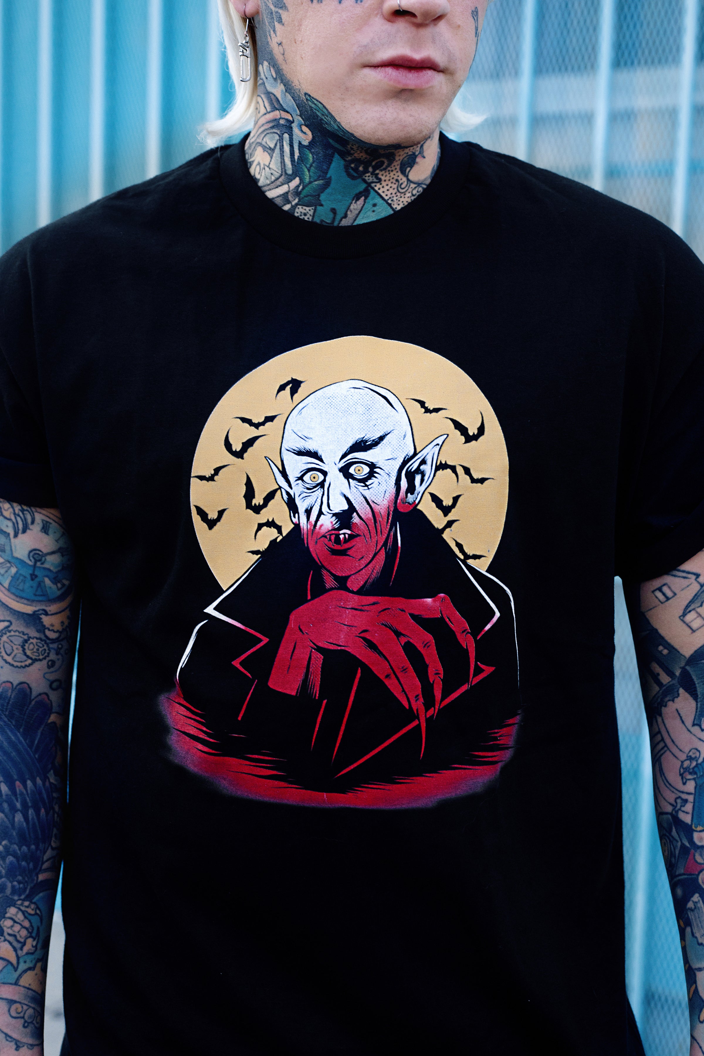 Black short sleeve T-shirt. Features white and orange image of vampire. Yellow full moon and black bats in background of image.
