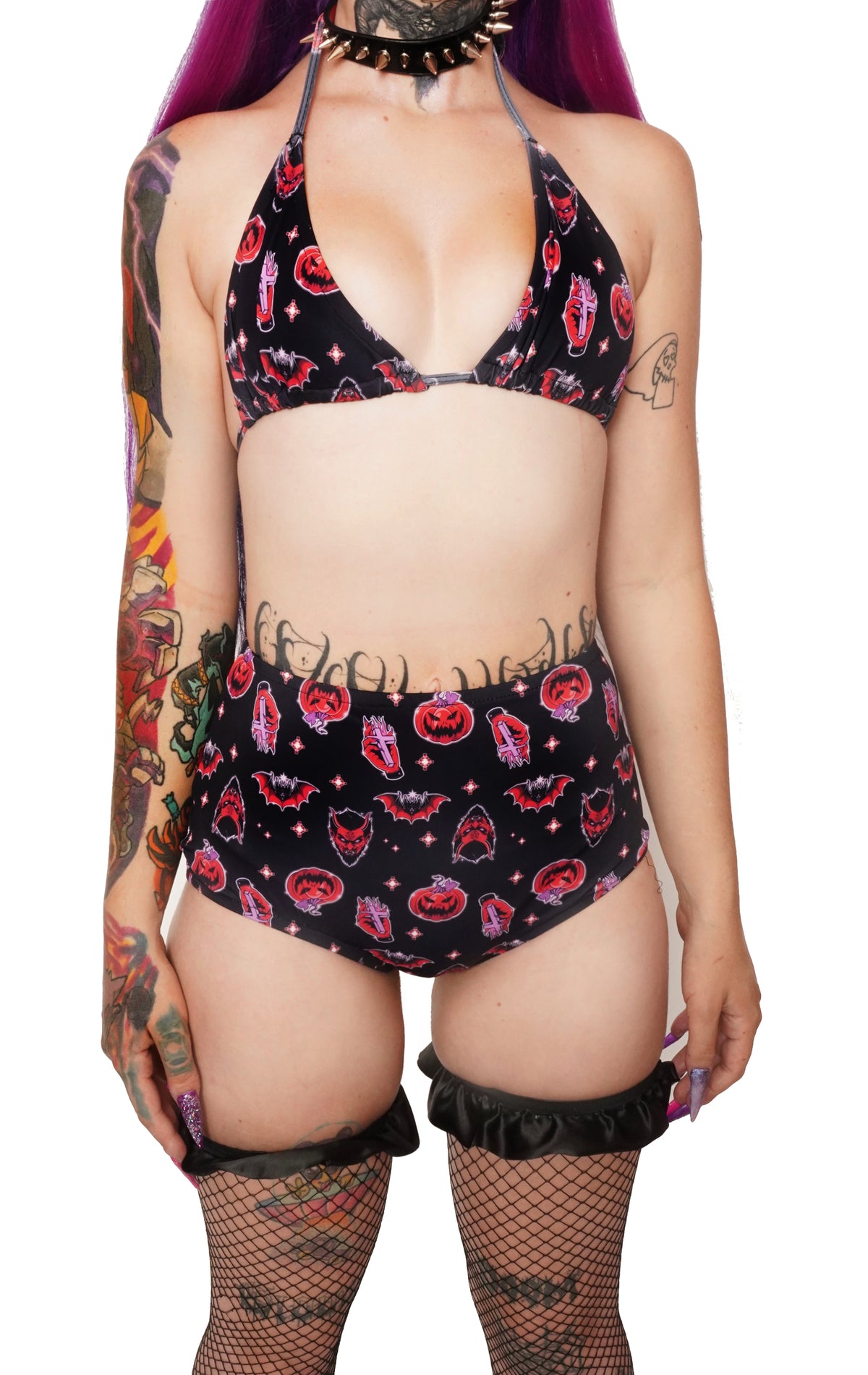 black halter thin strap bikini top and high waited bikini bottoms. Features black and orange images of pumpkins, bats, devil and hand holding cross.