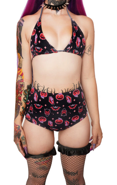 black halter thin strap bikini top and high waited bikini bottoms. Features black and orange images of pumpkins, bats, devil and hand holding cross.