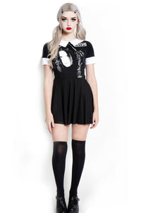 Black baby doll short sleeve dress with white collar and white cuffs. White print features man with black gloves holding his face. Inscription reads "NIN" in white.