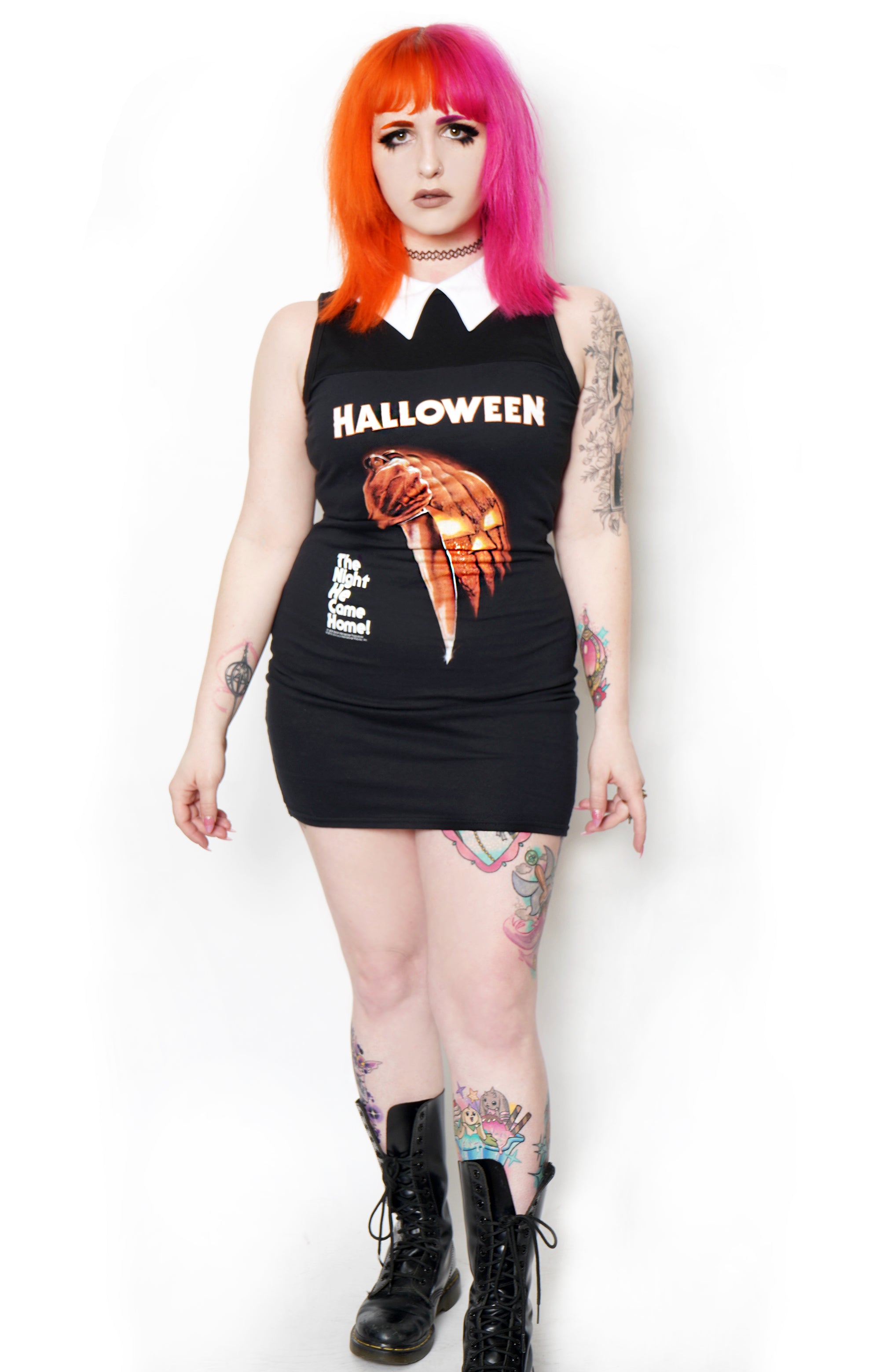 Black sleeveless mini dress with white polo collar. Print features pumpkin with knife and reads "Halloween" and "The Night He Comes Home" in white font
