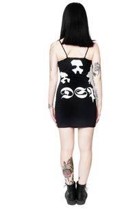 Back view black mini dress with thin straps and black lace trim neckline. Print in white features faces of three men