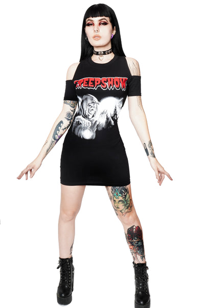 Black short sleeves mini dress with cut out shoulder detail. White print features cloaked monster with full moon in background. Inscription  reads "Creepshow" in red.