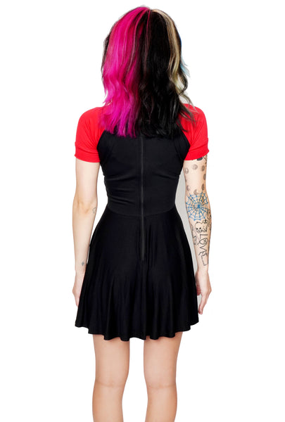 Back of black babydoll dress with red short sleeves and red trim neckline. Zipper on back of dress.