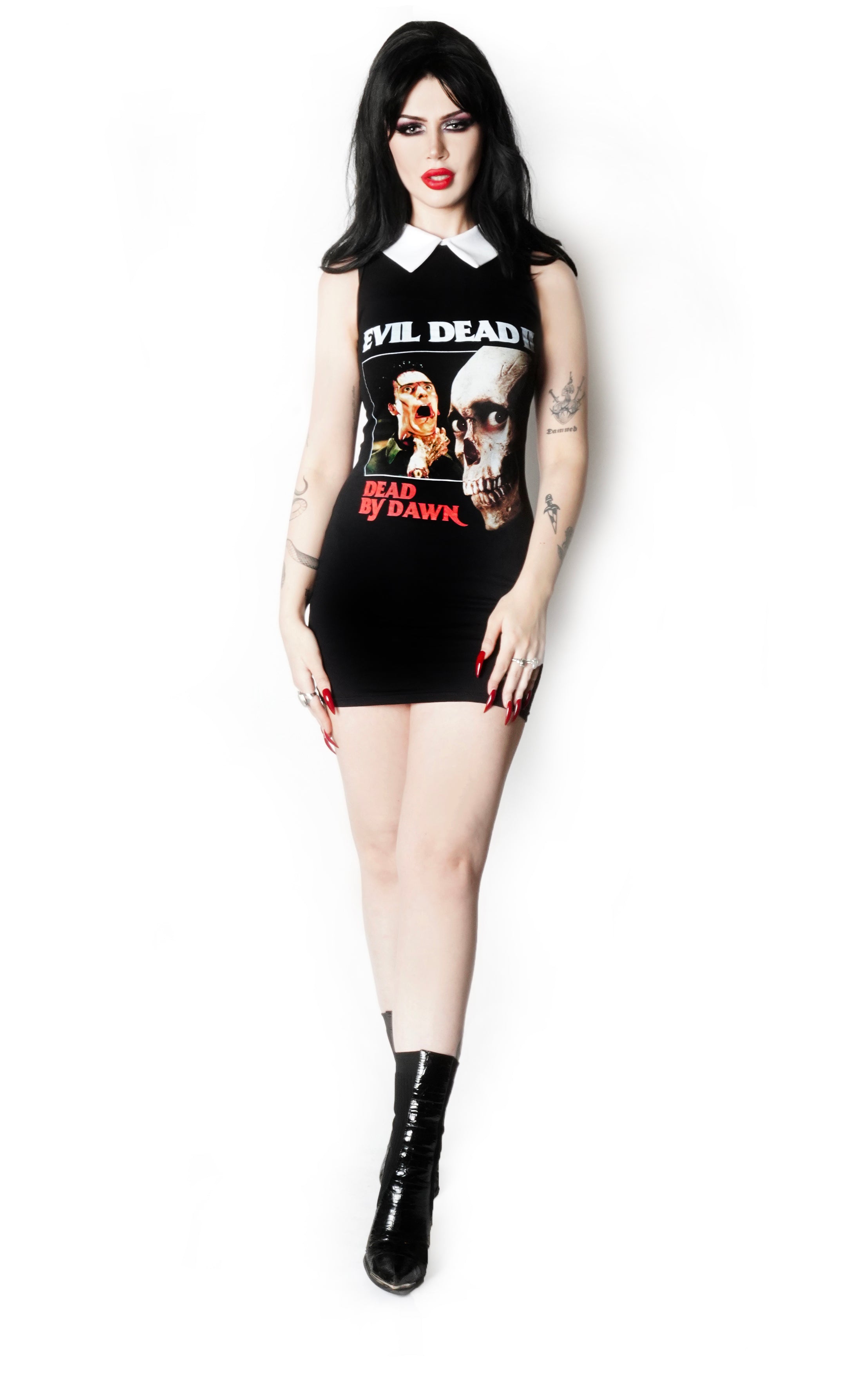 Black mini dress with white polo collar. Features picture of a skull and a man being choked by a severed hand. Inscription reads "Dead by Dawn" in red and "Evil Dead 2" in white font.