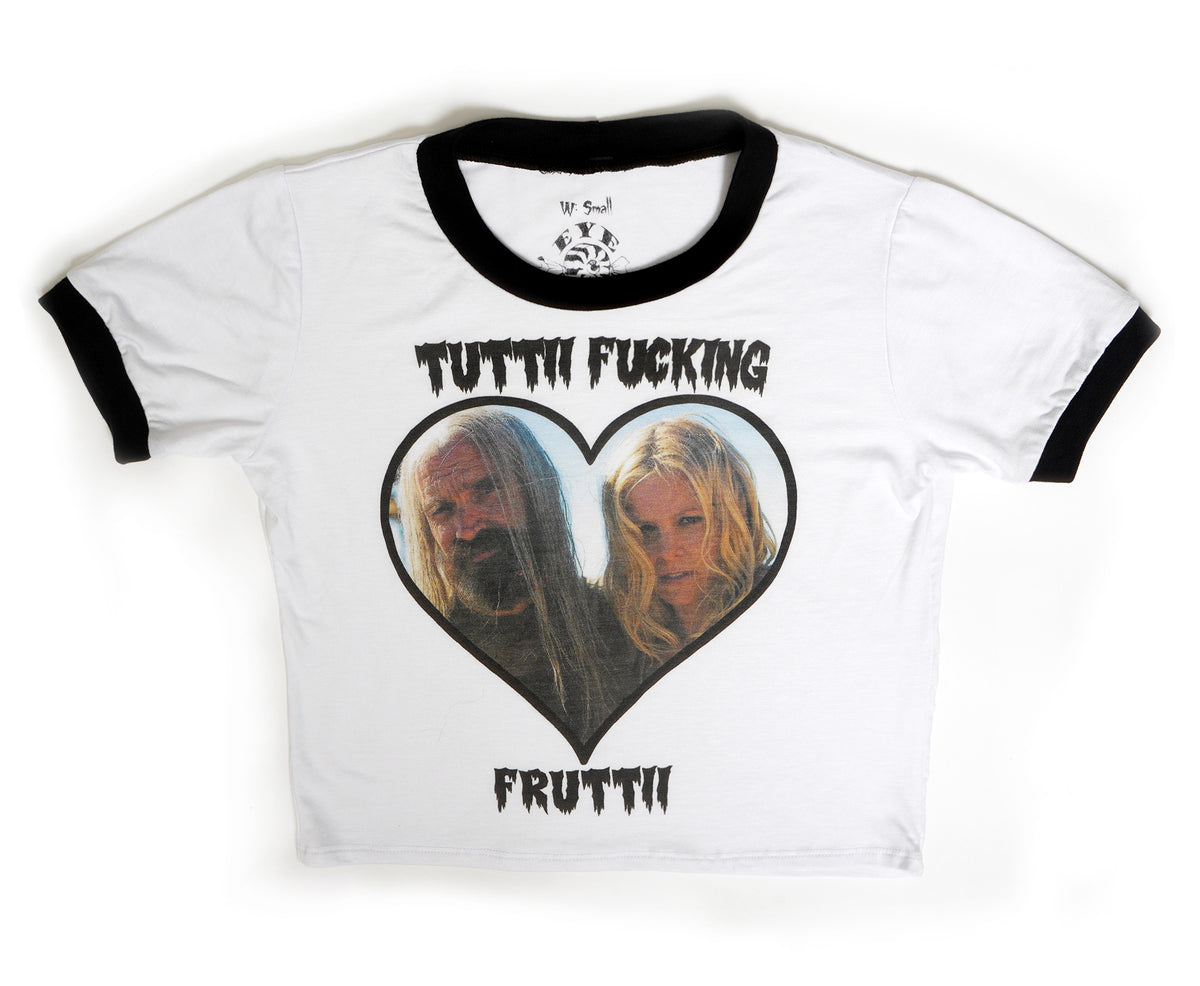 White ringer tee with black trim. Inscription in black reads "TUTTI FUCKING FRUTTII". Features picture of Otis and Baby from the movie "The Devil's Rejects" inside a heart shape.