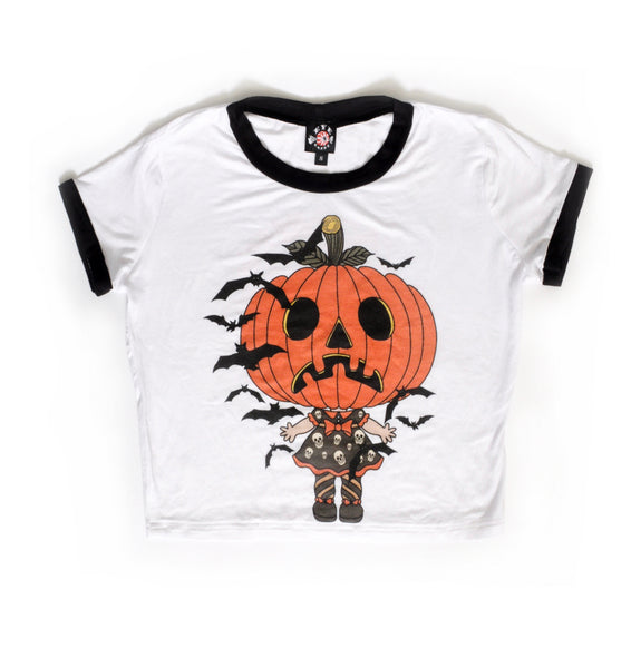 White ringer shirt with black trim. Features jack o lantern head wearing a dress with skulls and orange trim, orange collar and orange bow. Black bats flying around.