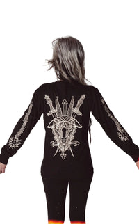 Back of black long sleeve shirt. Features goat with knives and cross. The sleeves have a print of ball and chain.