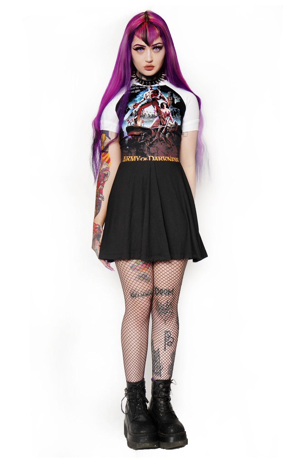 Solid black baby doll style dress with white baseball short sleeves and white trim neckline. Features image of man carrying a chainsaw with woman to her knees holding his leg. Battle and castle appear in the background. Inscription reads "Army of Darkness" in yellow.