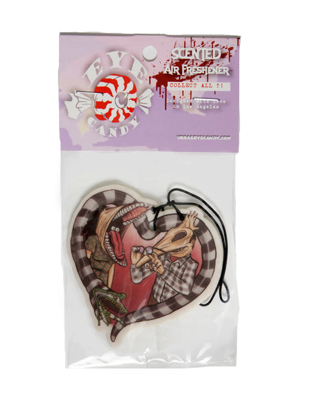 Air freshener with white elastic band. Features image of Barbara and Adam from the movie Beetlejuice. Barbara has face stretched with mouth open, tongue sticking out and eyes in mouth. Adam has his face stretched out with eyeballs on his fingers and glasses in hand. Black and white Beetlejuice snake around Adam and Barbara in the shape of a heart.