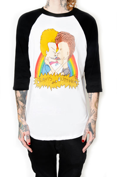 White baseball tee with black sleeves and black trim neckline. Features Beavis and Butthead kissing in front of a rainbow. Inscription reads "BEAVIS AND BUTTHEAD" in black.