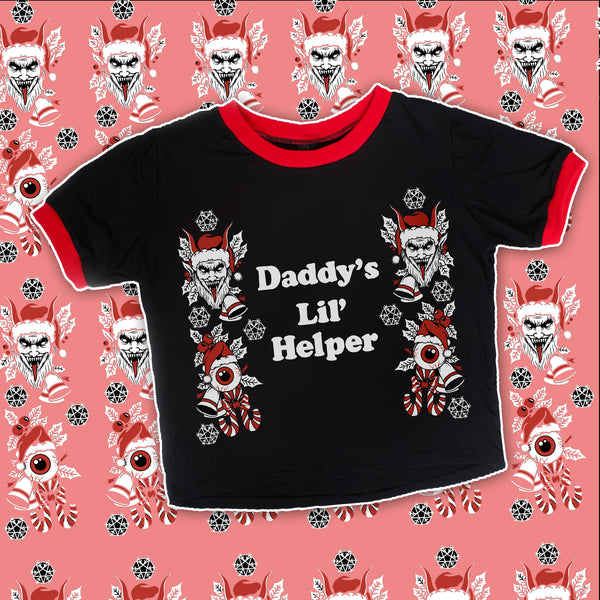 Black ringer tee with red trim. Print features evil holiday elves with snow, candy canes, and eyeballs. White font reads "Daddy's Lil' Helper".