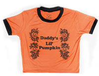 Orange ringer tee with black trim. Black print features pumpkins with leaves and black font that reads " Daddy's Lil' Pumpkin".
