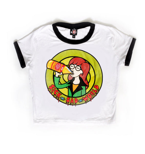 White ringer tee with black trim. Print shows green background and Daria animated character drinking a beer. Inscription reads "Sick Sad World" in red