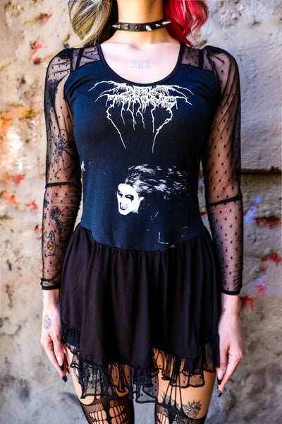 Black ballerina style dress with long sheer sleeves and sheer trim on skirt. Print shows man with corpse paint makeup. Inscription reads "Dark Throne" written in white font.
