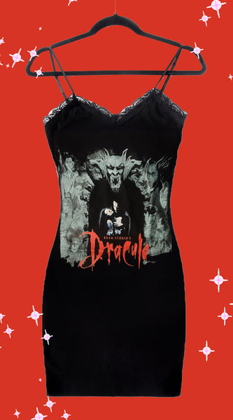 Black dress with thin straps and black lace trim neckline. Print features man and woman embracing with gargoyles surrounding. "Bram Stoker's Dracula" is written in red font