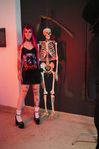 Black dress with thin straps and black lace trim neckline. Print features man and woman embracing with gargoyles surrounding. "Bram Stoker's Dracula" is written in red font