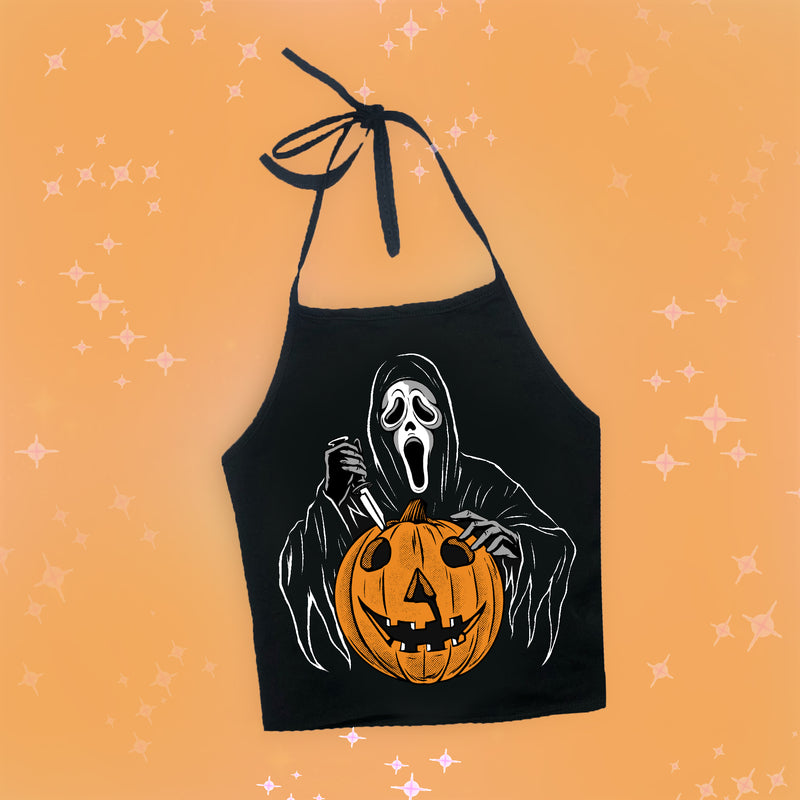 Black halter top with thin black straps to tie around neck. Features image of Ghostface from the movie Scream holding a knife with an orange jack o lantern in front of him.