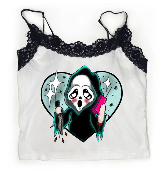 White tank top with thin black straps and black lace trim neckline. Print features Ghostface character from the movie Scream on pink telephone and knife in hand. Blue heart in the background.
