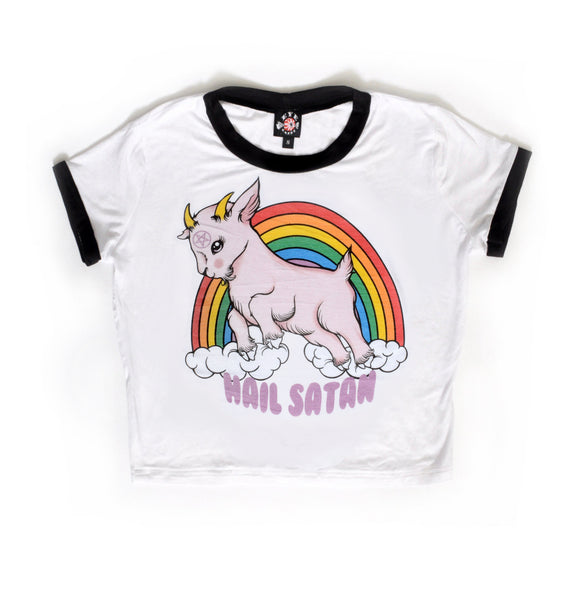 White ringer tee with black trim. Features animated pink goat with pentagram on forehead. Clouds and rainbow behind goat. Written underneath goat is "Hail Satan" in pink font.