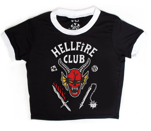 Black short sleeve ringer tee with white trim. Features image of devil's head at center with bloody sword and a flail. Inscription reads "HELLFIRE CLUB" in white.