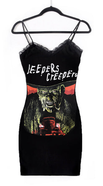 Black thin strap mini dress with black lace trim neckline. Features image of creeper from the movie Jeepers Creepers. Inscription reads "JEEPERS CREEPERS" in white.