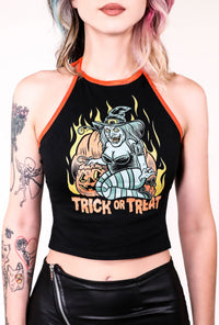 Black halter top with thin orange tie around neck straps and orange trim. Features green witch with an evil smile kneeling by orange pumpkins with yellow flames in background. Inscription reads "Trick or Treat" in orange.