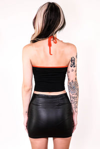 Back of black halter top with thin orange straps that tie around neck and orange trim.