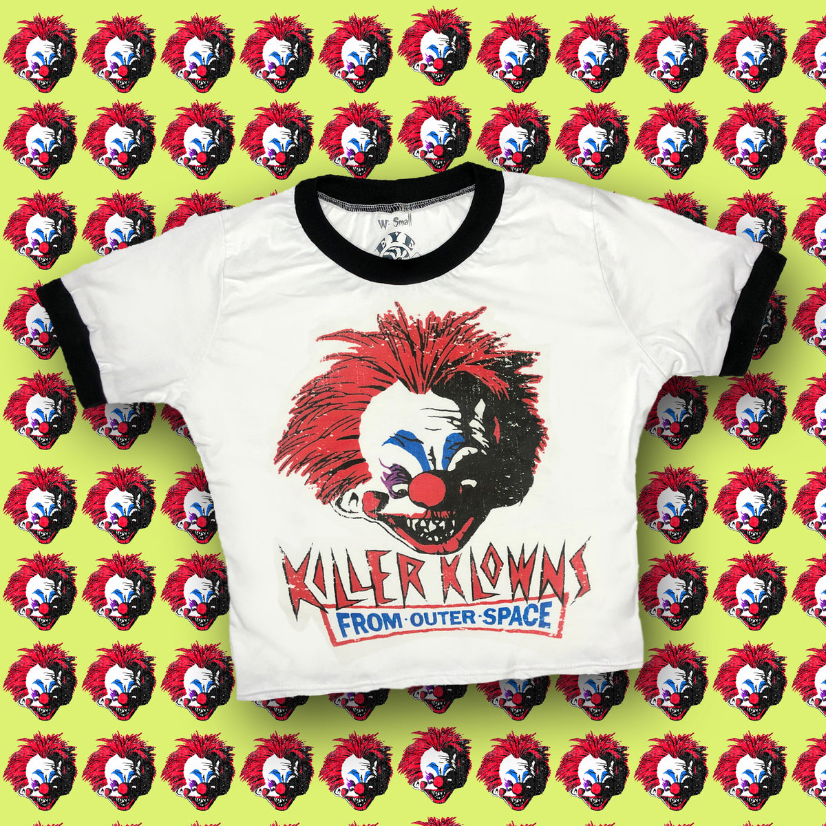 White ringer tee with black trim. Features image of evil clown head. Inscription reads "KILLER KLOWNS" in red and "FROM OUTER SPACE" in blue.