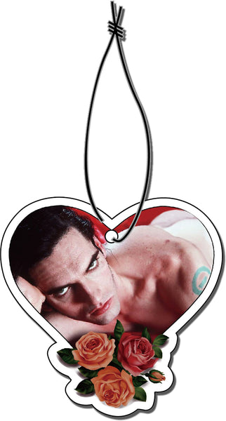 Heart shaped air freshener with white elastic band. Features image of Peter Steele laying in bed with red sheets. Roses at bottom of heart.