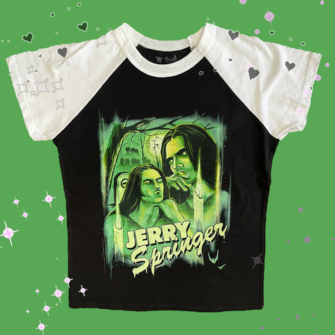 Black baseball tee with white short sleeve and white trim neckline. Features green print image of Peter Steele in two different thinking poses. Lit up candle in front of image and tree in background. Green inscription reads "JERRY Springer"